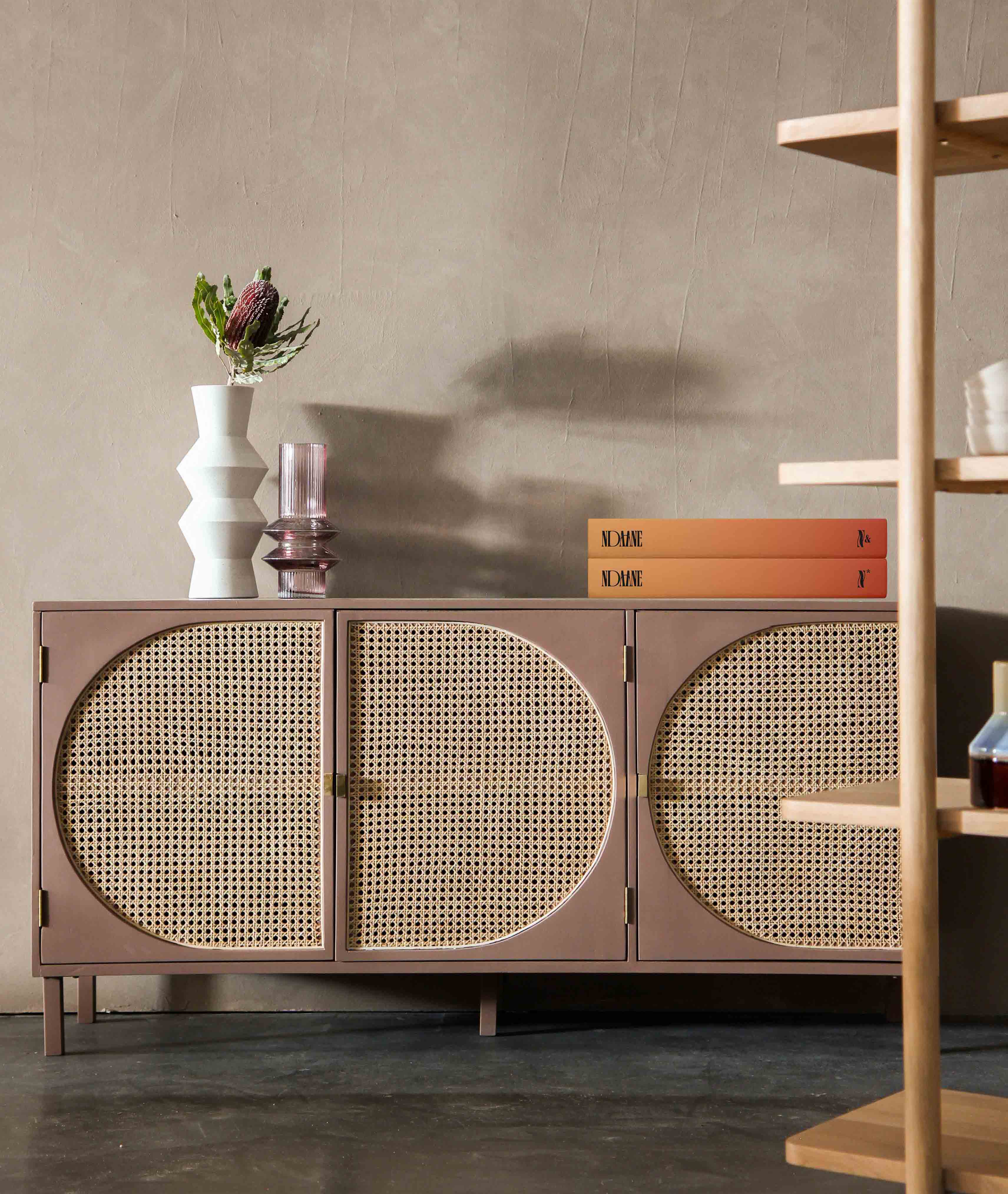 A credenza with some books and flower vases placed on top