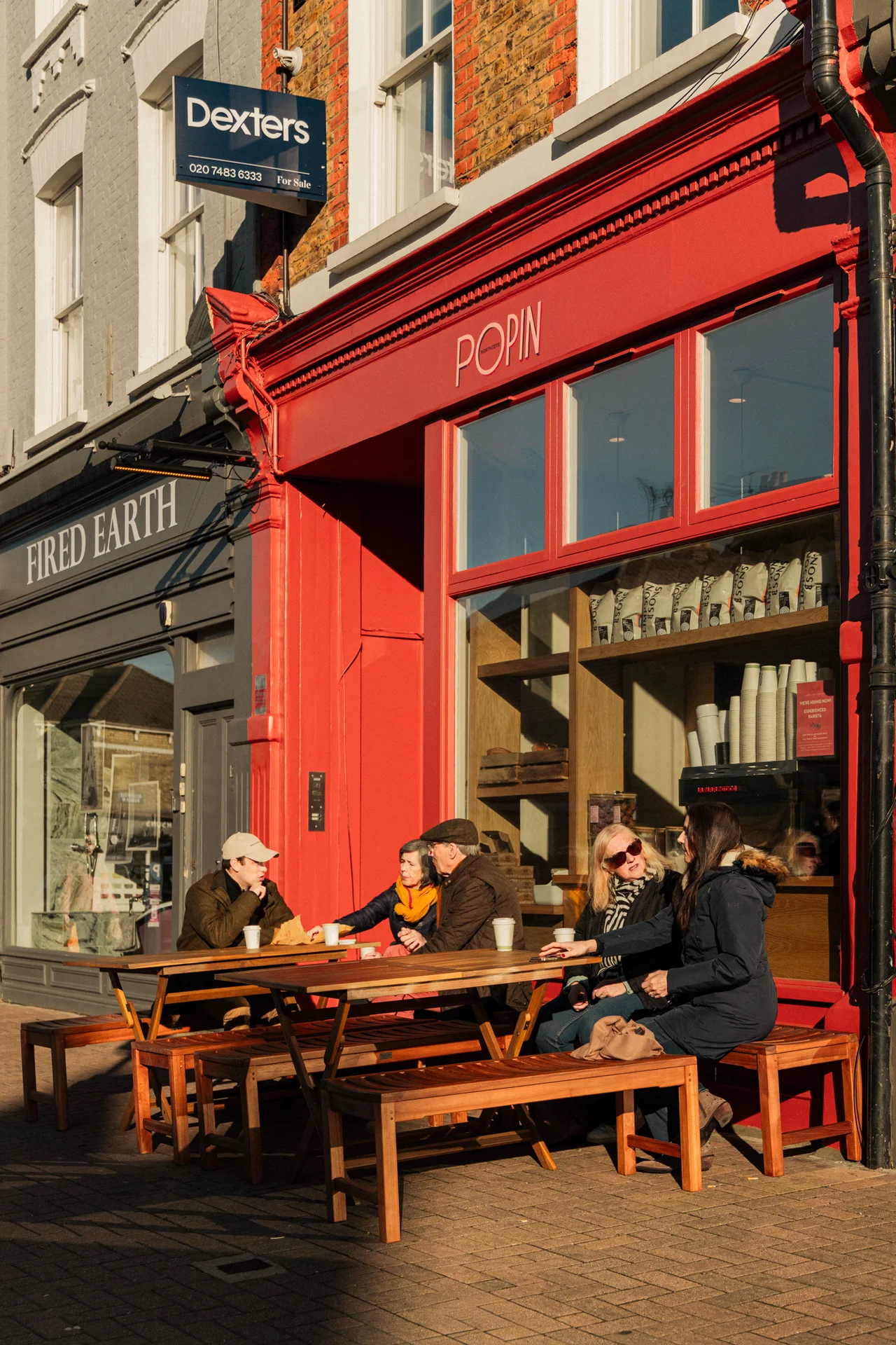 People at the tables outside POPIN in winter sun