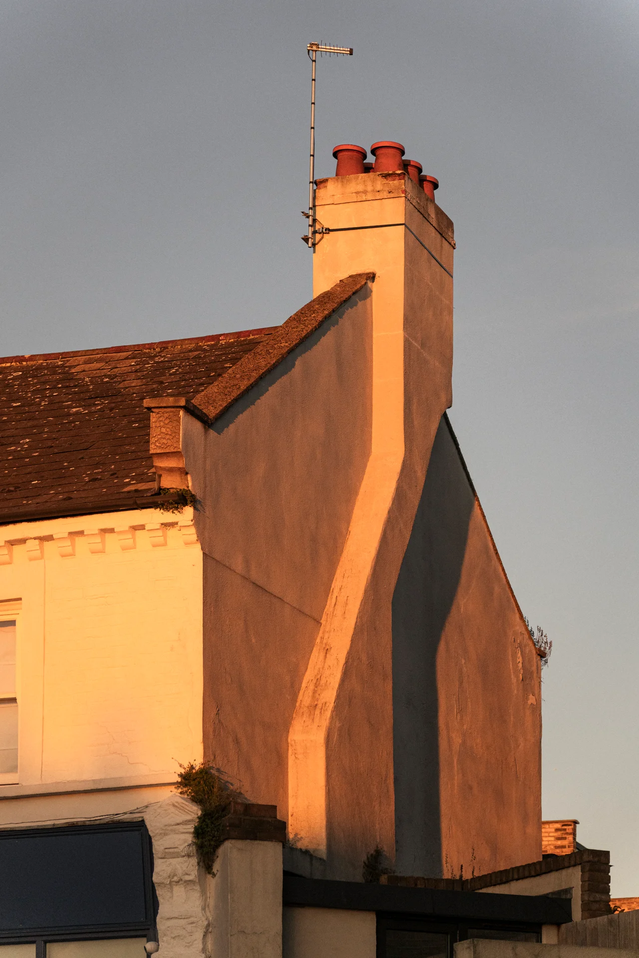 Chimney stacks and gable end in low evening sun
